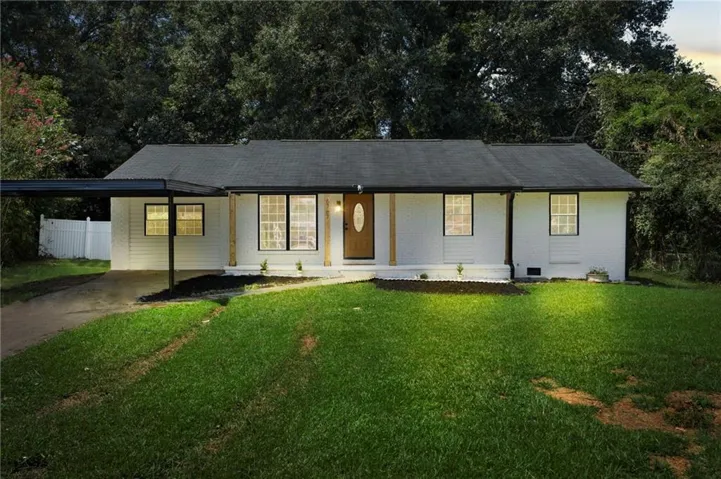 White horizontal siding exterior with black trim windows, a covered carport, and a dark asphalt shingle roof