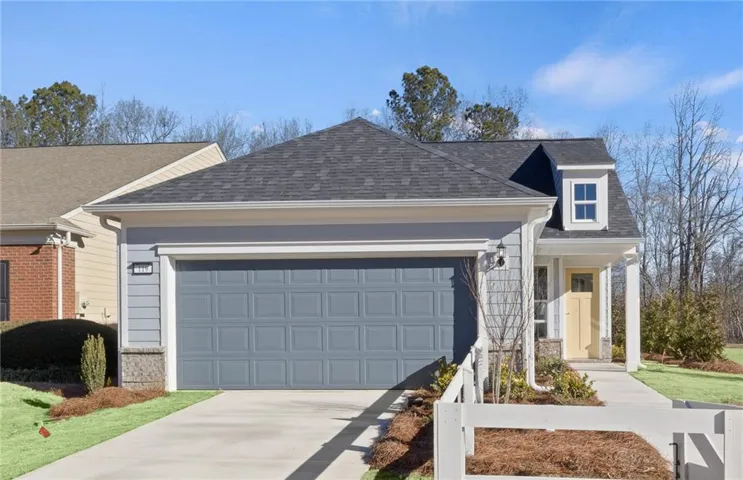 Exterior featuring a dormer window, covered porch, attached garage, and stone accents