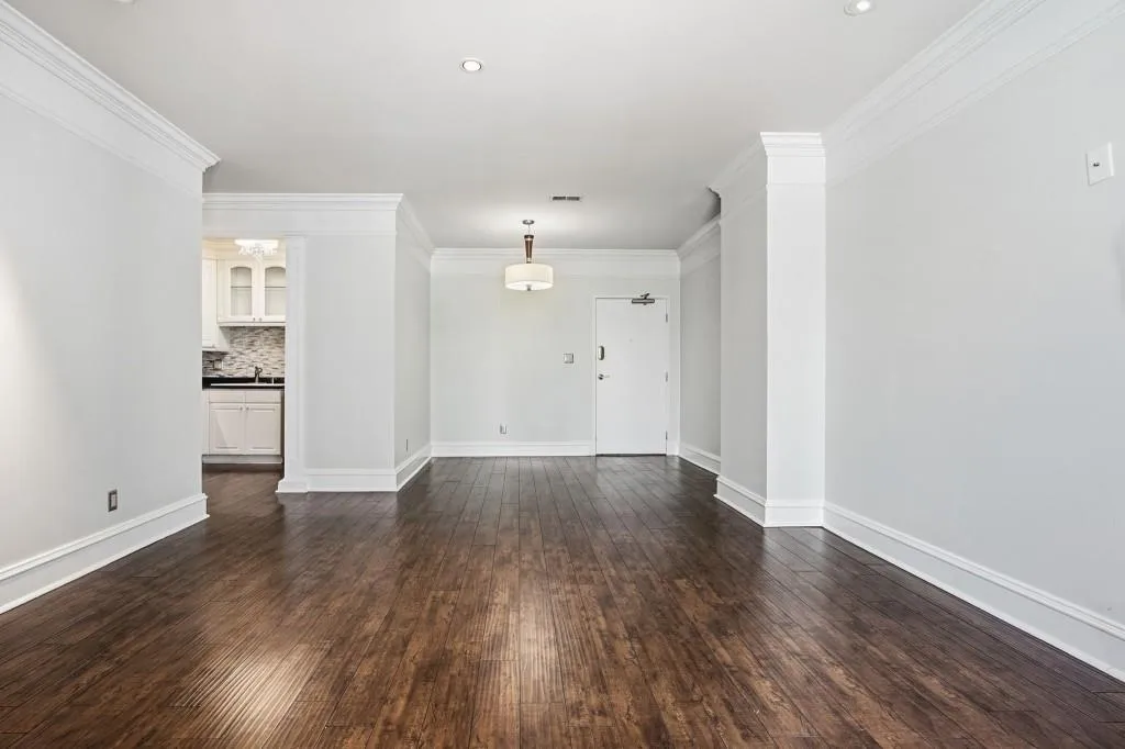 The spacious open concept living area, with hardwood floors and view of kitchen