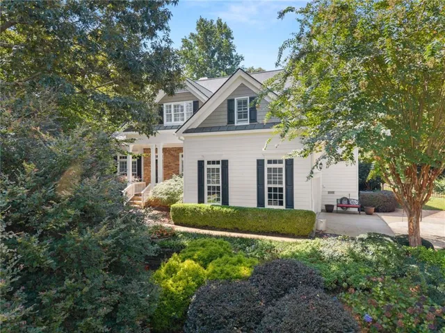 Two-story exterior with white siding and brick accents