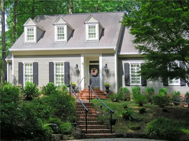 Traditional-style residence featuring light gray siding with contrasting black shutters