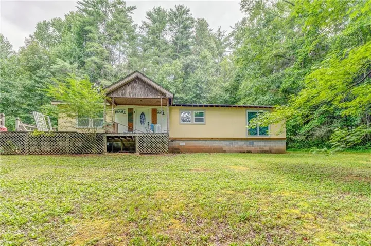 View of front of house featuring crawl space, a front lawn, and a porch