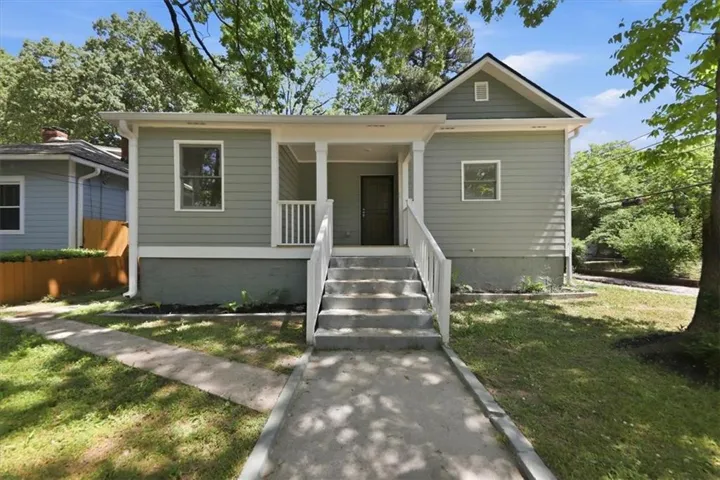 Contemporary single-story residence with a covered porch featuring white columns and railing