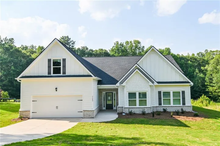 View of front of home with a garage and a front yard