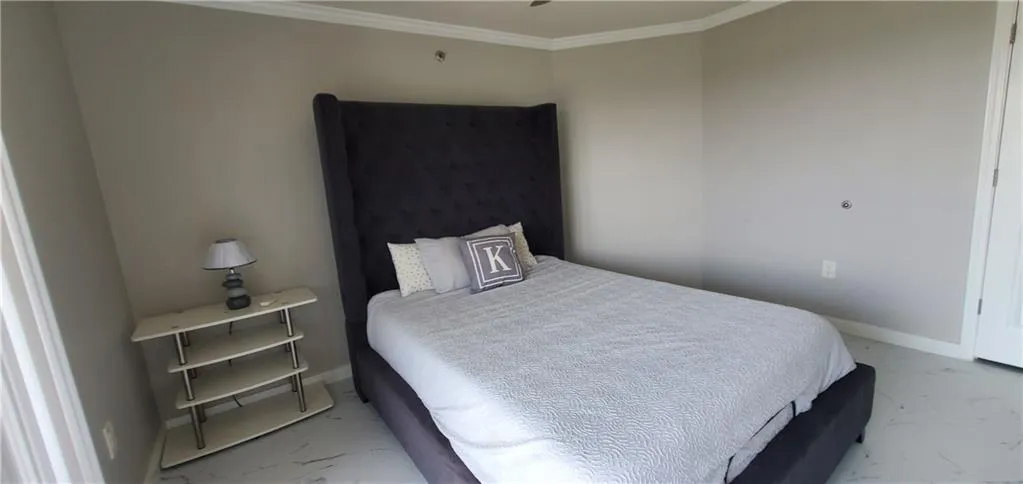Bedroom with light tile patterned floors and crown molding