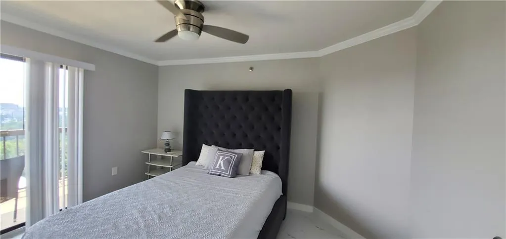 Bedroom with ceiling fan and crown molding