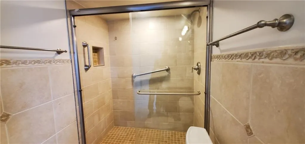 Bathroom featuring toilet and a shower with door