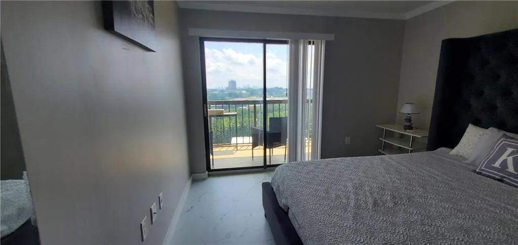 Bedroom with ornamental molding and access to outside