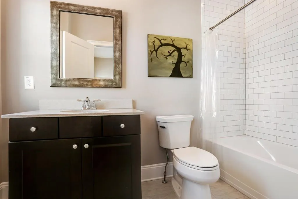 Ensuite bathroom in secondary upper level guest bedroom. The cabinets are a level 5 upgrade with silestone countertop. Level 7 tiled floor upgrade. Level 6 tile surround in the tub/shower with tile taken to the ceiling.
