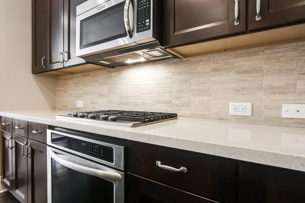 All appliances were upgraded to stainless steel KitchenAid appliances. The beautiful backsplash is a Level 9 travertine dove vein cut planks that are 1x6 installed horizontally.