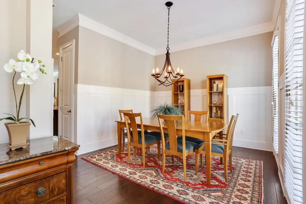 Separate dining room with upgraded wainscoting trim and upgraded chandler light fixture.