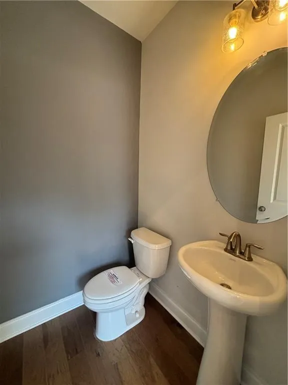 Bathroom with baseboards and dark wood-type flooring