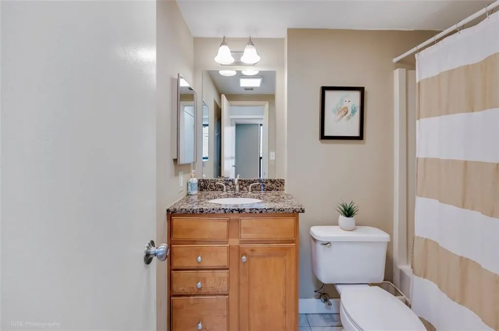 Your bathroom boasts vanity storage, bright lighting, and a shower/tub combo.
