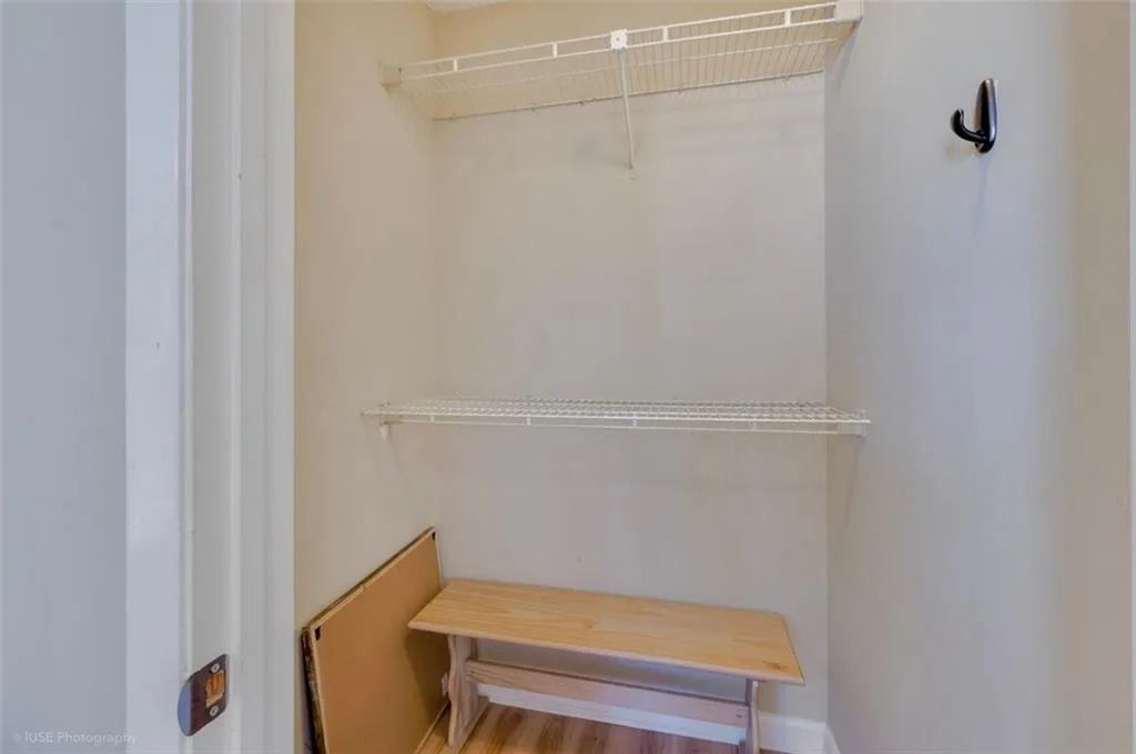 The spacious bedroom offers a panoramic view of Atlantic Station, with a ceiling fan and walk in closet.