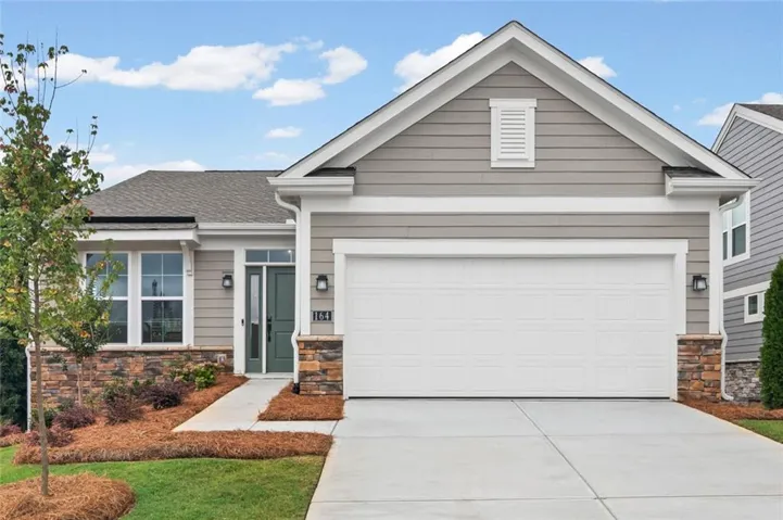 Single-story residence featuring light gray siding, a prominent white garage door, and a dark green entry door