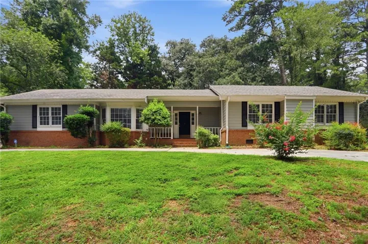 Ranch-style residence featuring a combination brick and siding facade, black window shutters, and a covered front entry with white railings