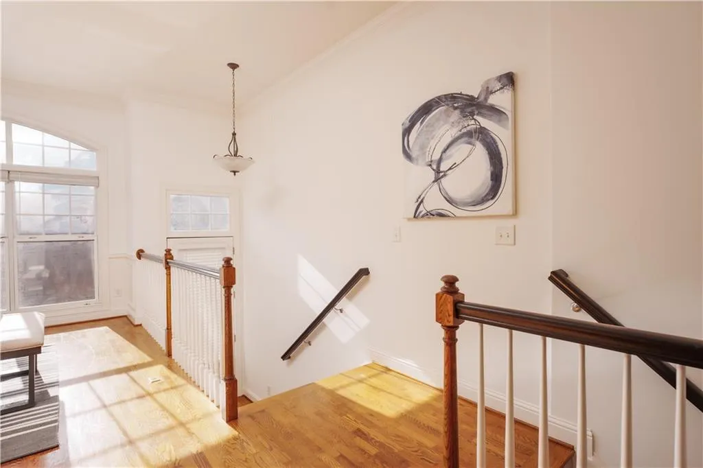 Staircase with ornamental molding and wood finished floors