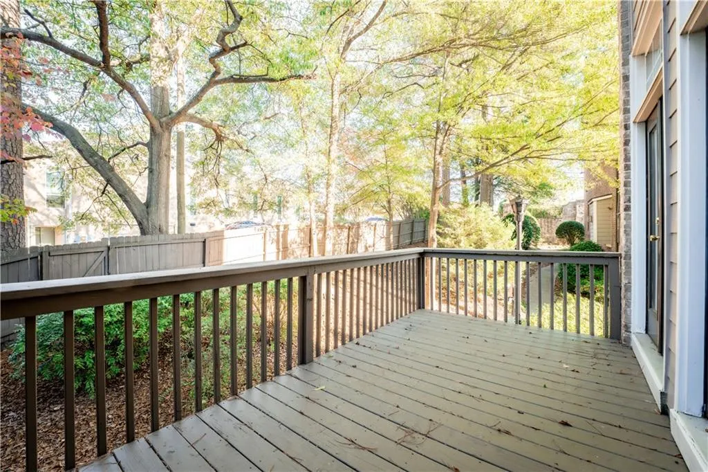Wooden terrace with a fenced backyard