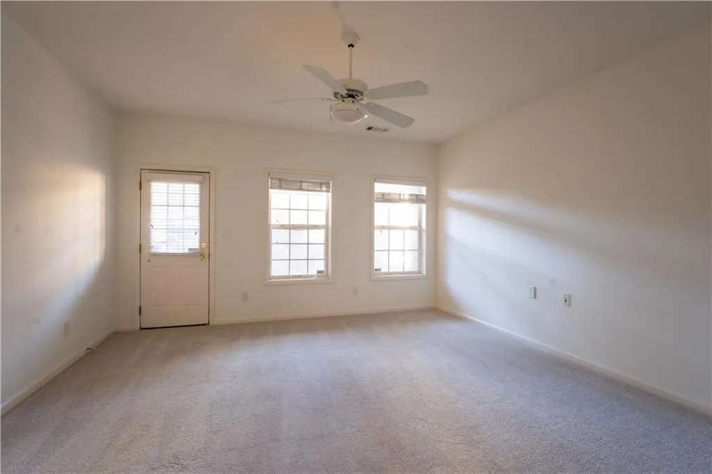 Unfurnished room with light carpet and a ceiling fan