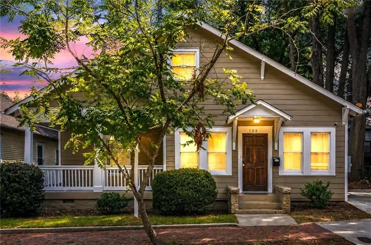 Craftsman-style exterior featuring horizontal siding, a covered porch with white railing, and a gabled roofline