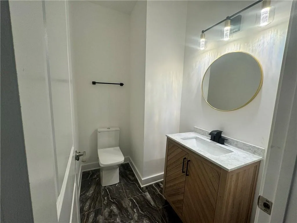 Bathroom with vanity, toilet, and tile patterned floors