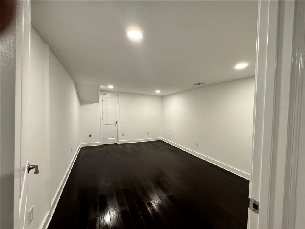 Basement with dark wood-type flooring