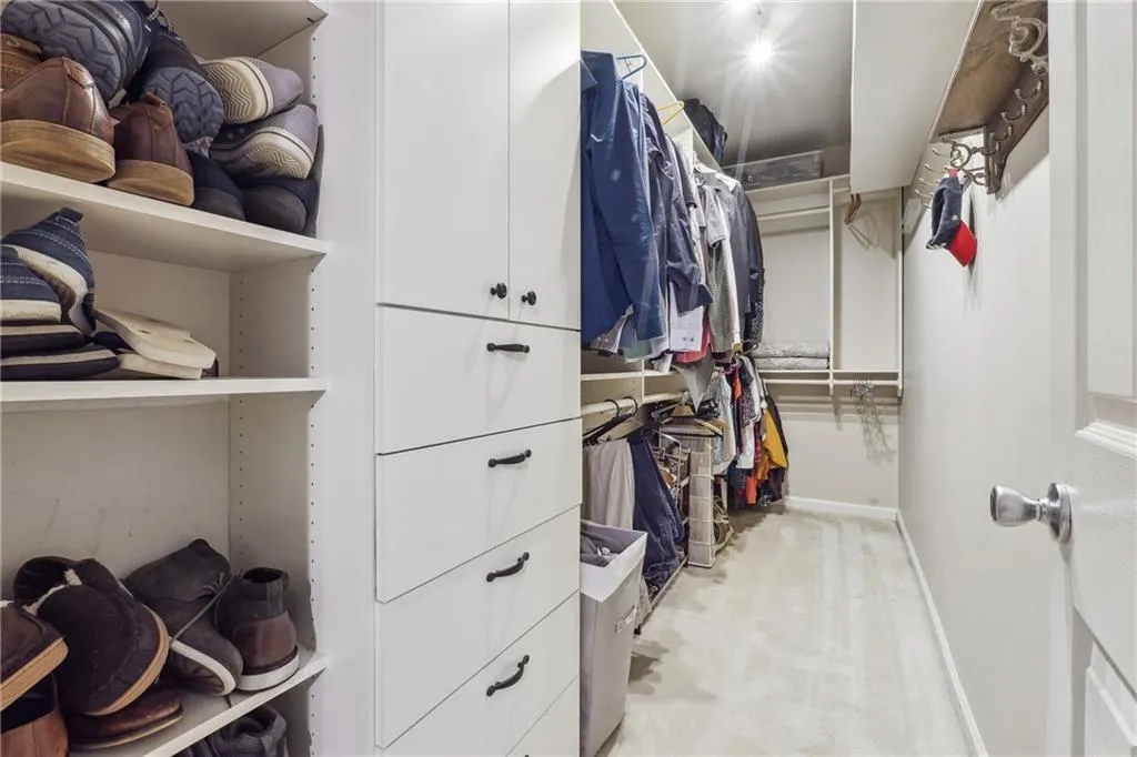 large walk in closet in primary bedroom with custom cabinetry