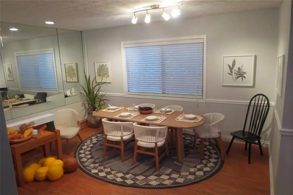 Dining space with rail lighting and hardwood / wood-style flooring