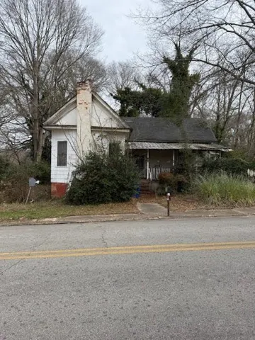 Bungalow-style house featuring covered porch and a chimney
