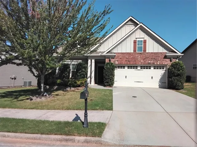 Single-story residence featuring a brick and siding facade, a double-car garage, and a concrete driveway