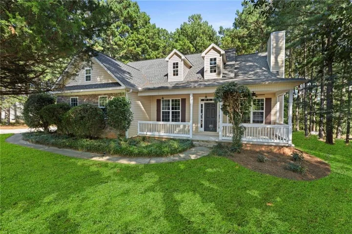 Siding and brick exterior with a covered front porch, white railing, and a prominent chimney