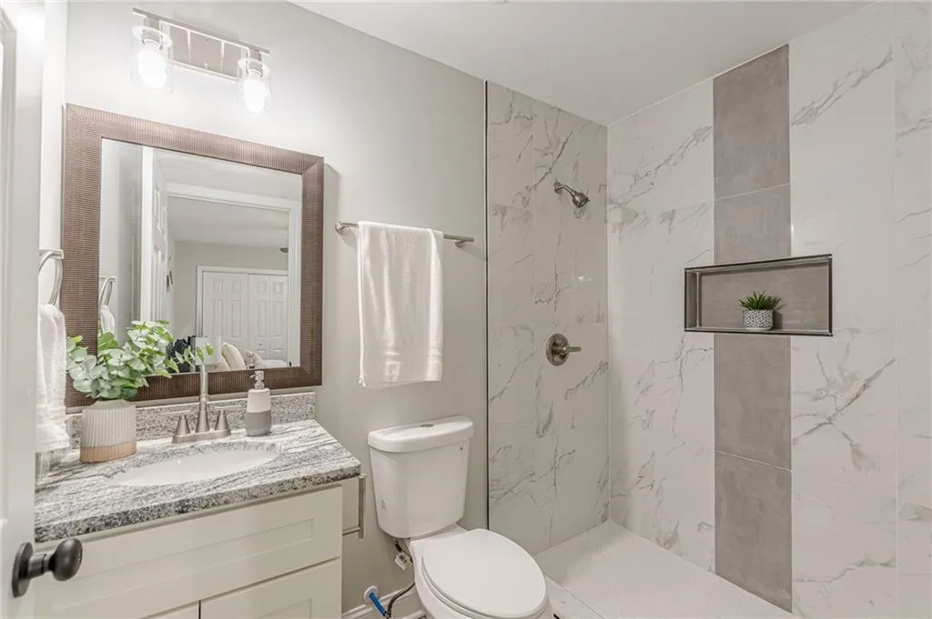 Full bathroom featuring vanity and a marble finish shower
