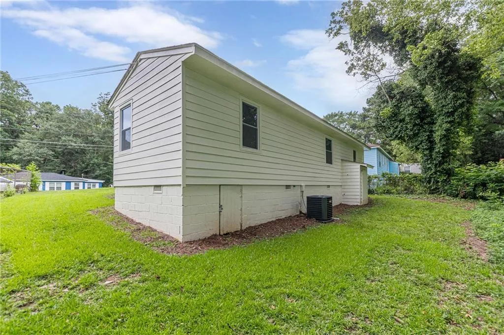 View of home's exterior with a yard and crawl space