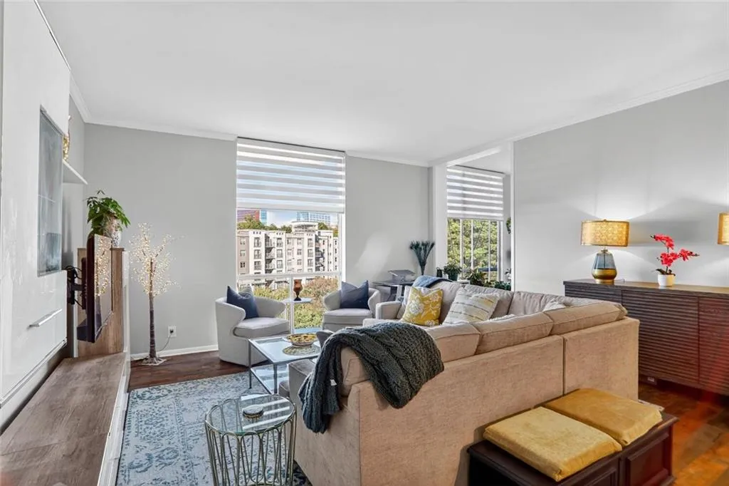 Living area featuring crown molding and dark wood-style floors