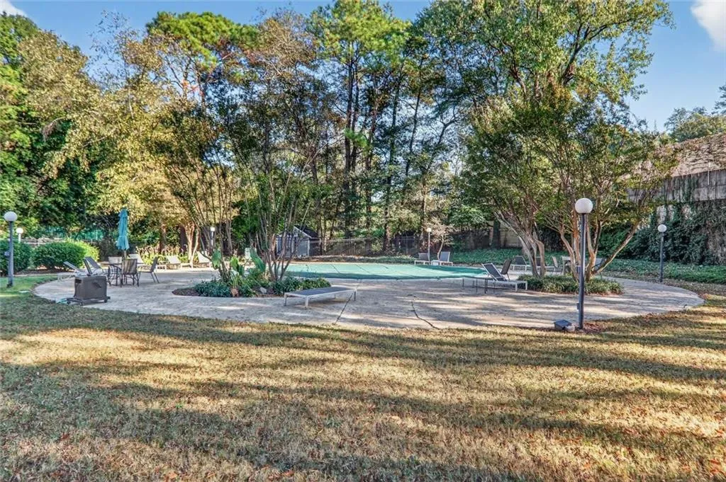 View of yard featuring a patio area and view of wooded area