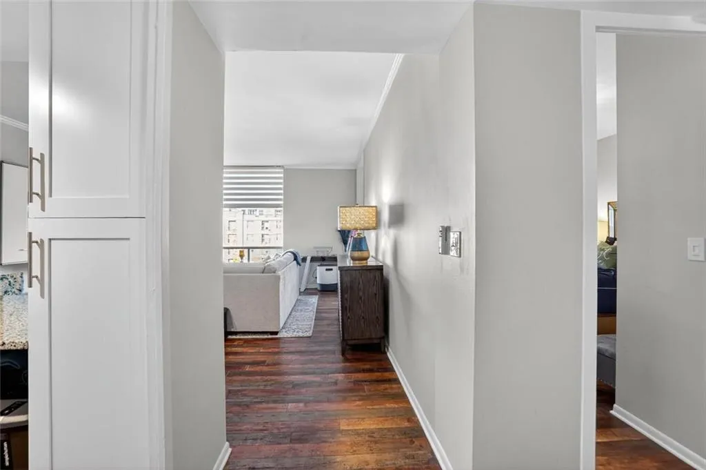 Corridor with dark wood-style floors and crown molding