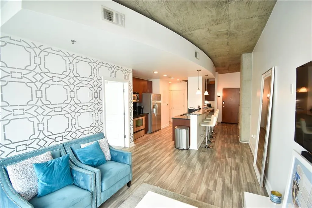 Kitchen featuring a kitchen breakfast bar, light wood finished floors, a peninsula, decorative light fixtures, and stainless steel appliances