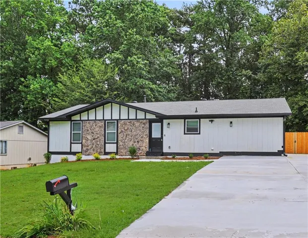 Ranch-style exterior with stone veneer and white siding accents