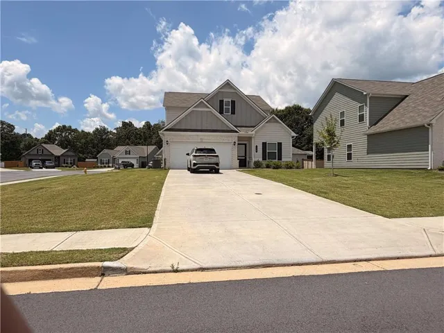 Modern two-story home with a two-car garage, concrete driveway, and a well-maintained lawn
