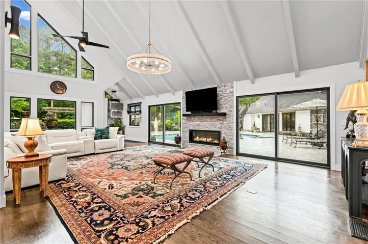 Huge living room with light-flooding windows and view of the pool and gardens.