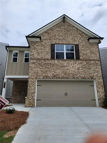 Brick Colonial with two-car attached garage, professional driveway, and gable roofline
