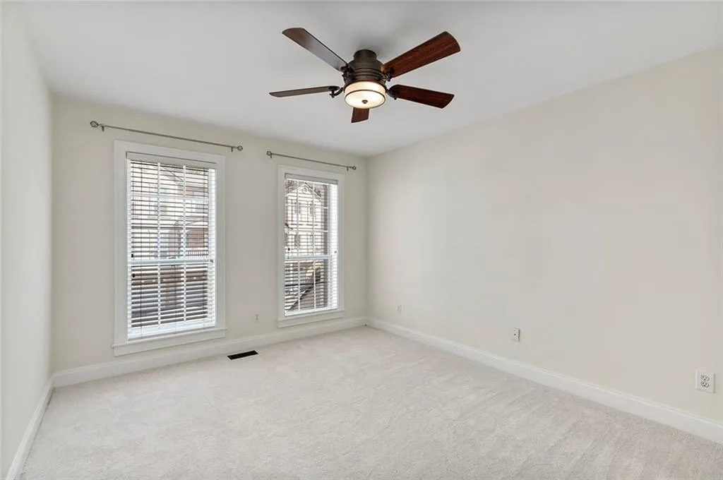 Bedroom with a ceiling fan, light colored carpet, visible vents, and baseboards