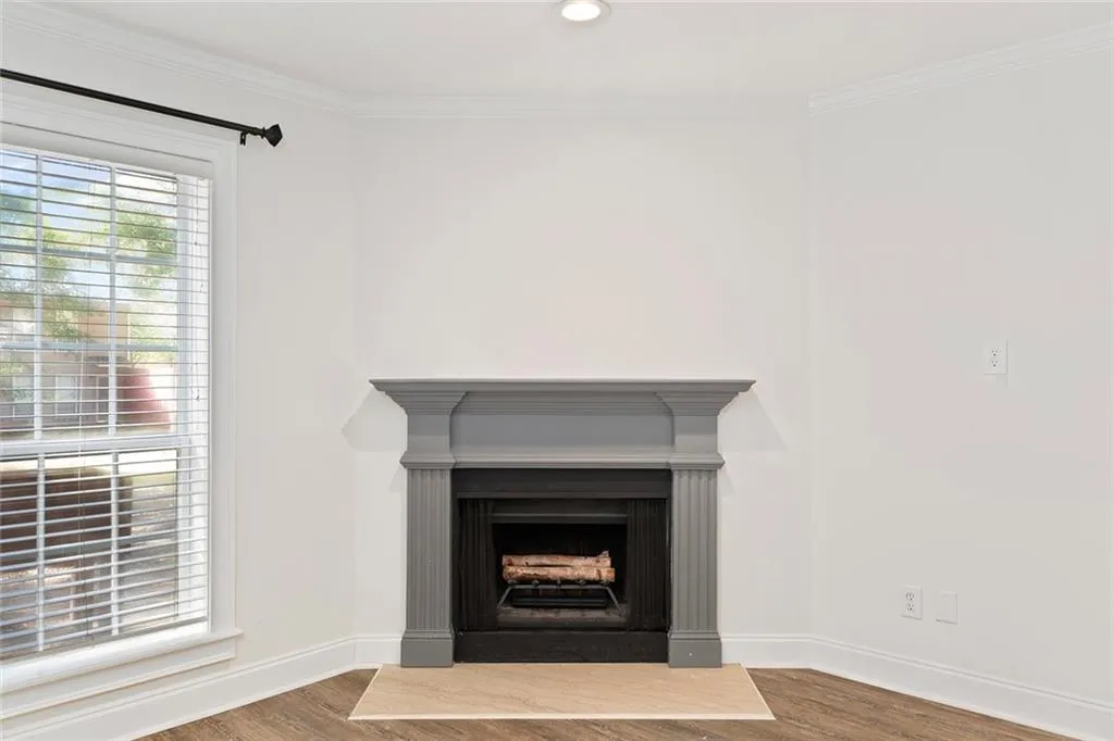 Interior details with recessed lighting, a fireplace, wood finished floors, baseboards, and crown molding
