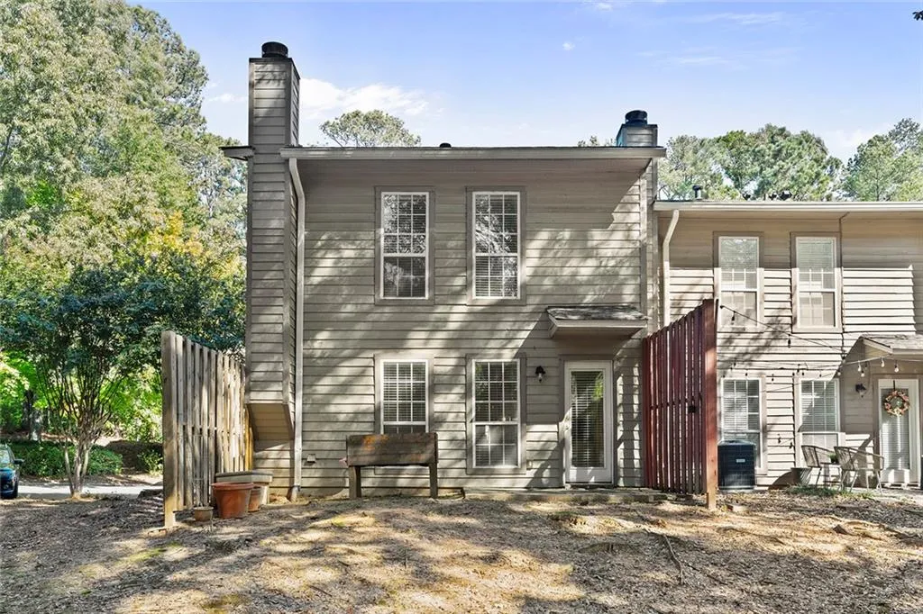 Rear view of house with a chimney and central AC