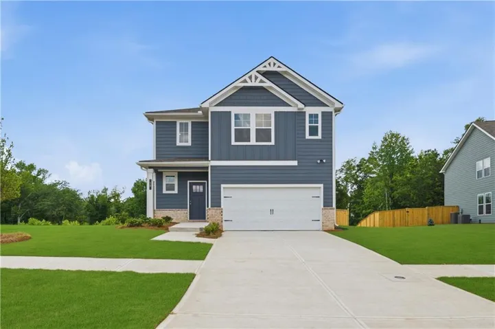 Two-story home with blue siding and white trim, featuring a prominent front-facing gable with decorative accents