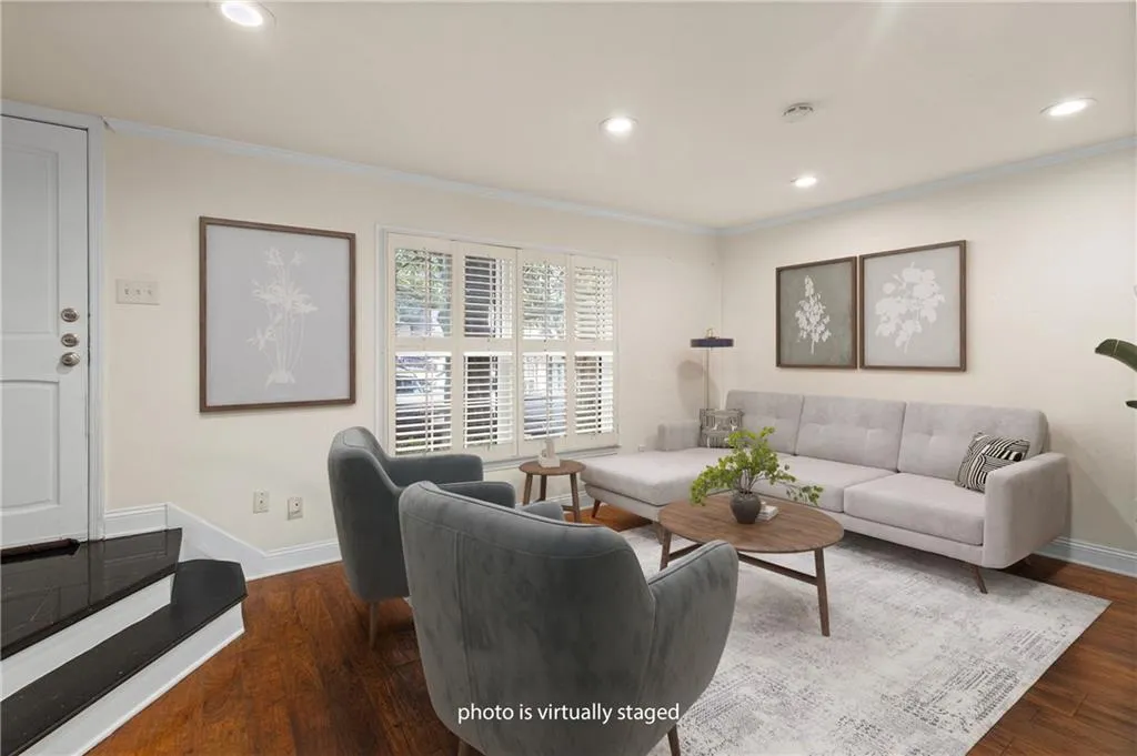 Living area with ornamental molding, recessed lighting, and dark wood-style floors