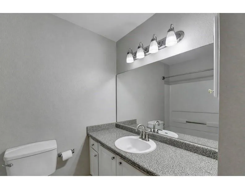Bathroom featuring a textured wall and vanity