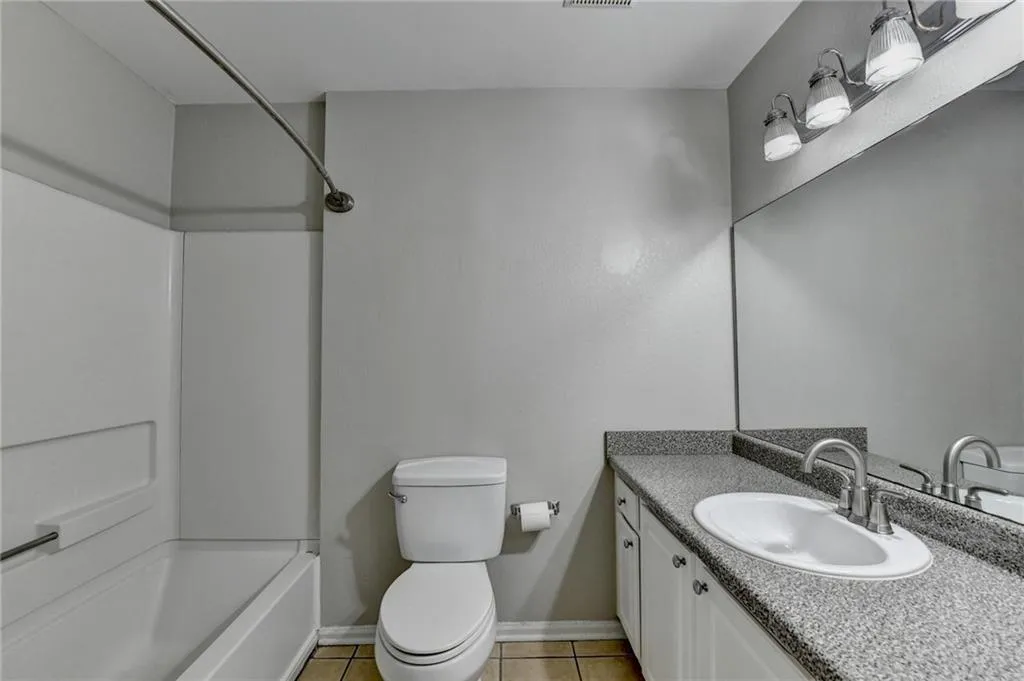 Bathroom with vanity, shower / bath combination, and light tile patterned floors