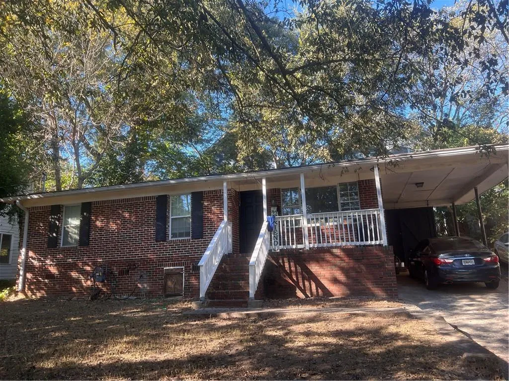 Single story home featuring a porch, a carport, brick siding, and concrete driveway Single story home featuring a porch, a carport, brick siding, and concrete driveway