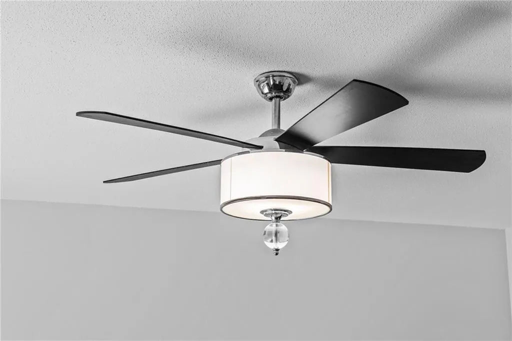 Contemporary remote controlled, lighted ceiling fan in living room.